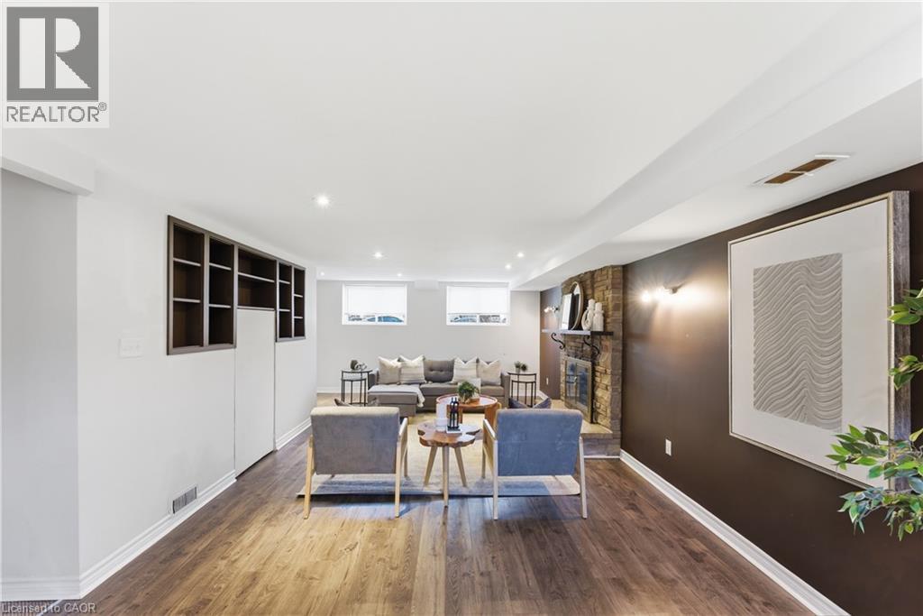 Spacious recreation room featuring wood-finish flooring, recessed lighting, and a stone fireplace