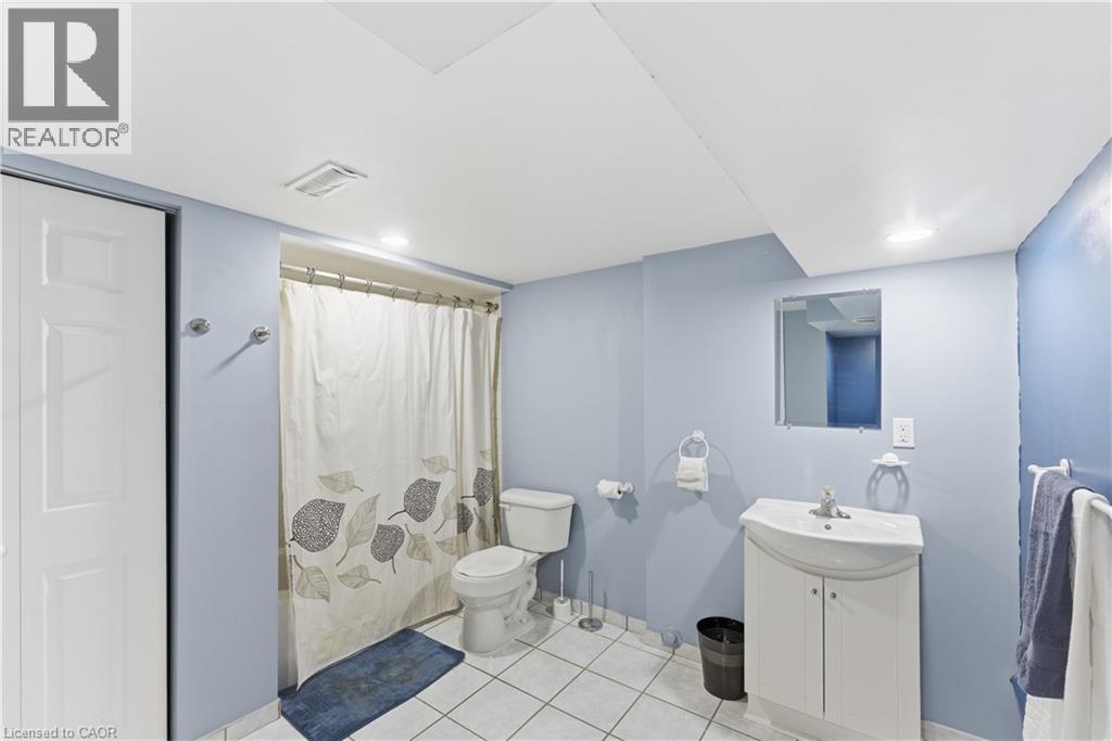 Bathroom featuring light blue walls, white floor tiling, and a white vanity with an integrated sink