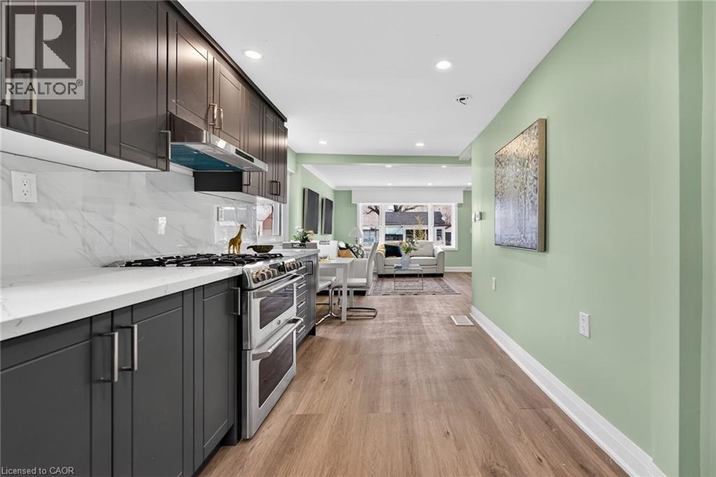 Gourmet kitchen featuring dark wood cabinetry, white countertops, and a full-height marble-patterned backsplash