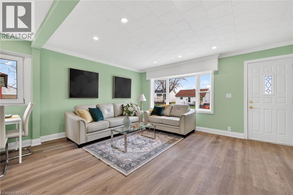 Open-concept living space featuring wood-finish flooring, recessed lighting, and a front entry door with decorative glass inserts