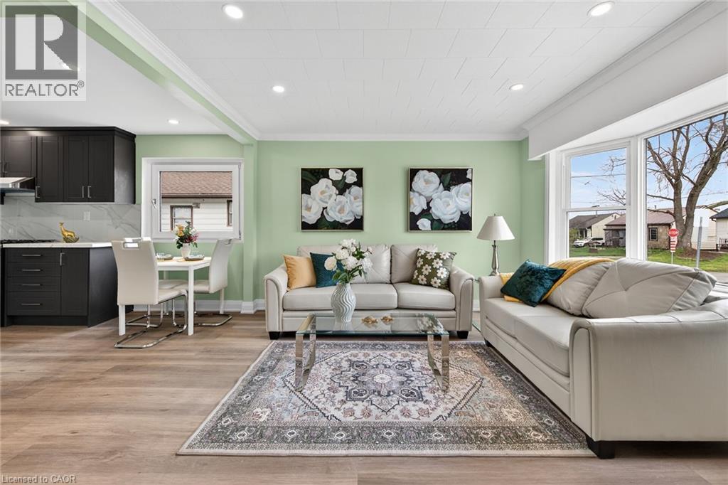 Open-concept living area featuring wood-finish flooring, recessed lighting, and a bay window