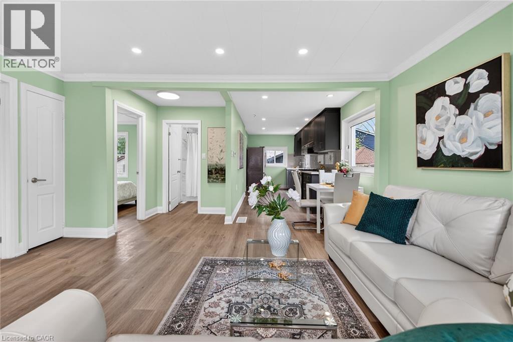 Open-concept living area featuring wood-finish flooring, recessed lighting, and light green wall finishes