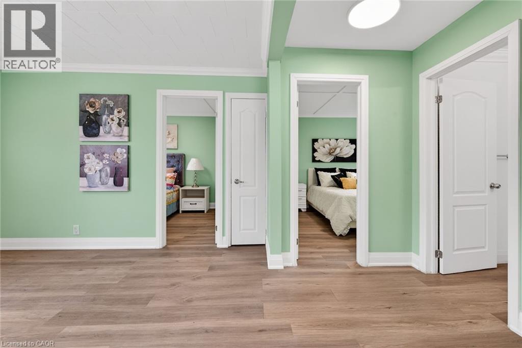Wood-finish flooring extends throughout this interior space, featuring light green walls and white trim
