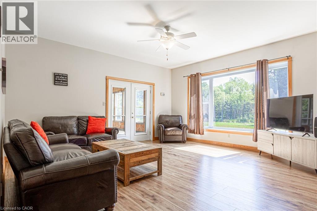 Bright living area featuring wood-finish flooring, a ceiling fan, and light-toned walls