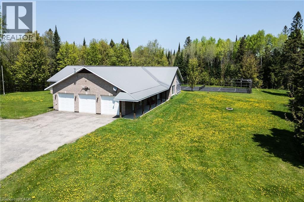 Brick-clad property with a three-car garage and a metal roof