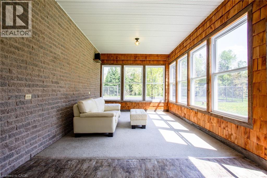 Sun-drenched room featuring a full wall of windows and wood shake siding
