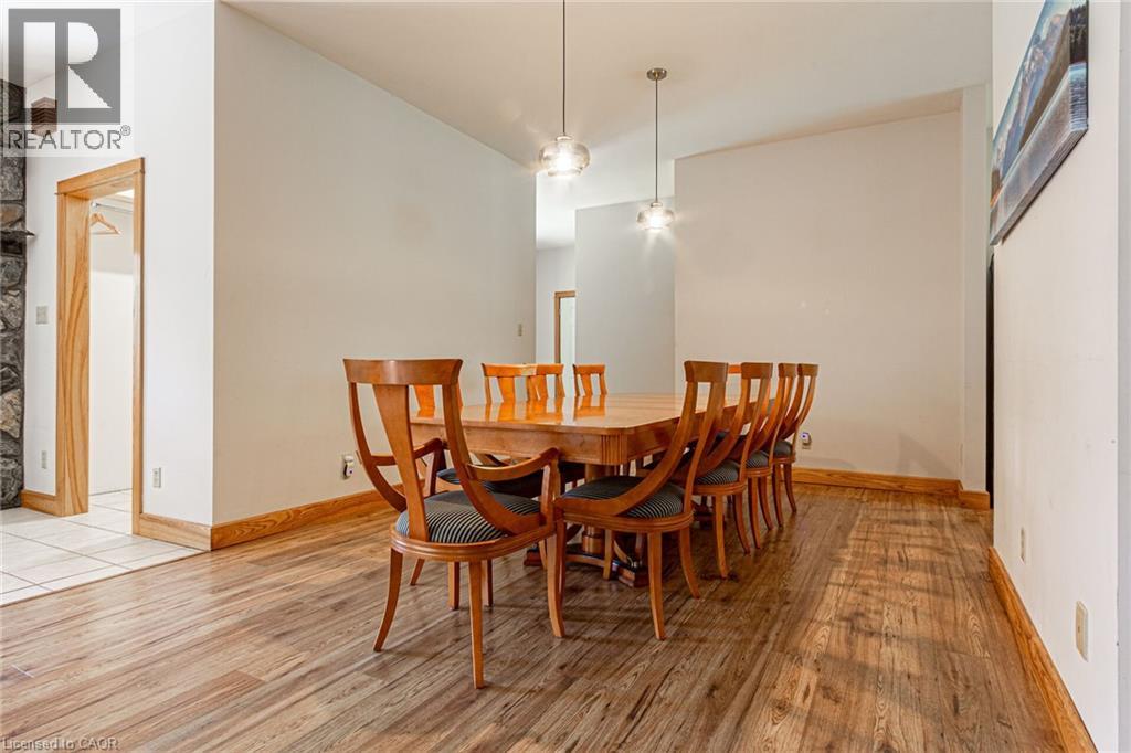 Spacious dining area featuring wood-finish flooring, light-toned walls, and recessed lighting