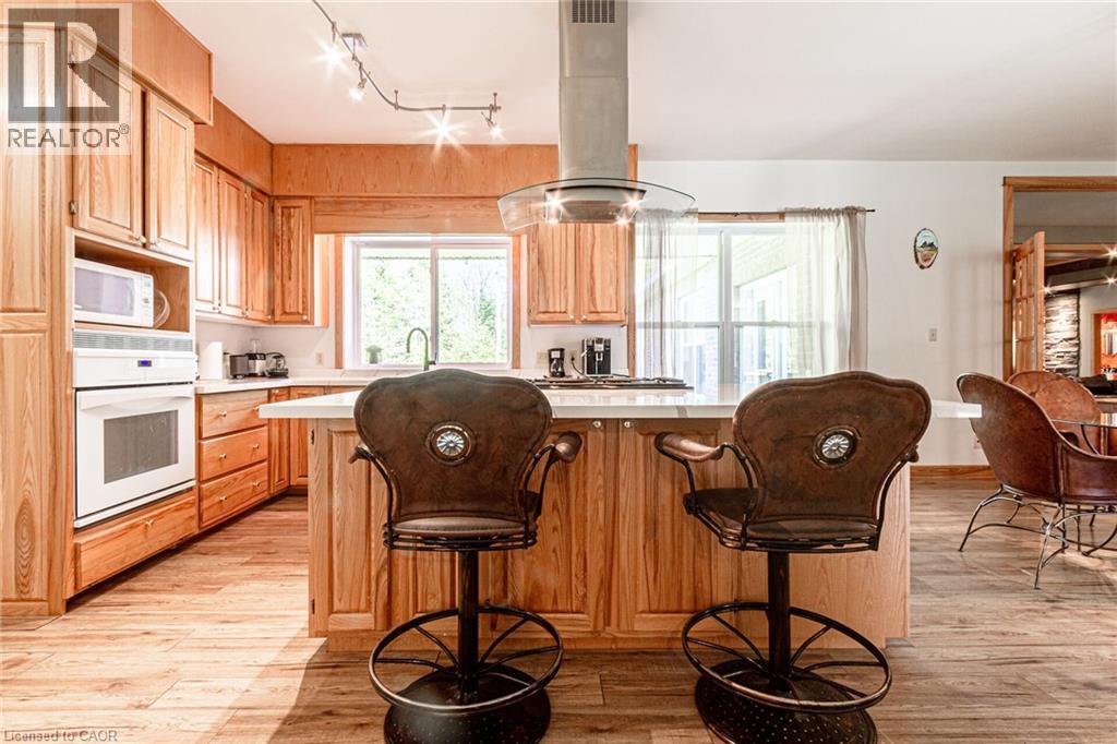 Spacious kitchen featuring warm wood cabinetry, built-in appliances, and a central island with countertop seating