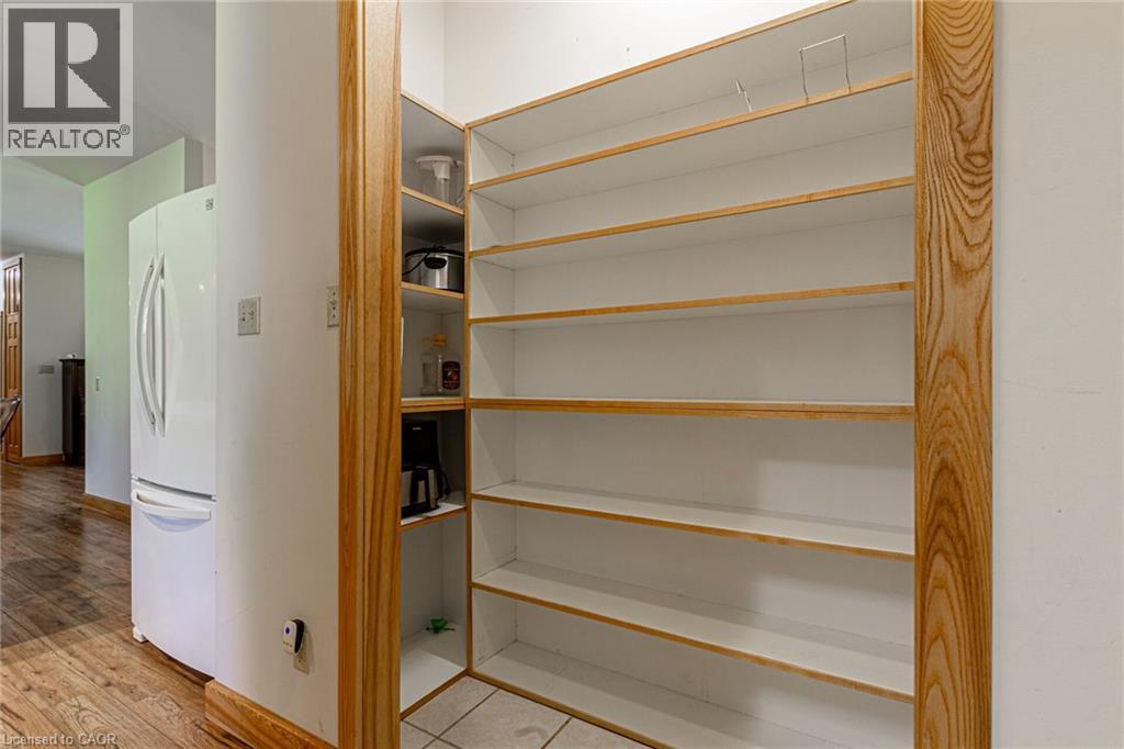 Floor-to-ceiling pantry shelving with light wood trim and tiled flooring