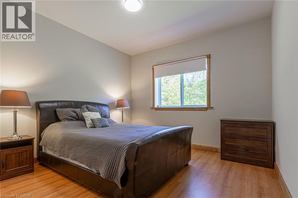 Light-filled room featuring wood-finish flooring, a window with a roller shade, and neutral wall tones