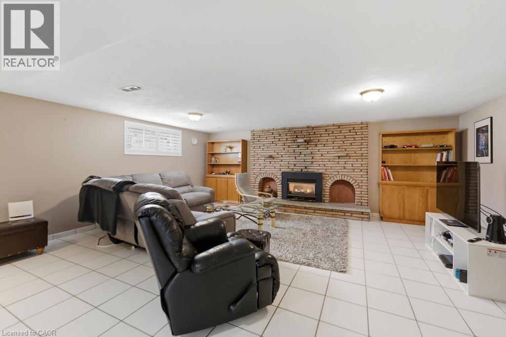 Spacious living area featuring a prominent brick fireplace with a raised hearth, flanked by two arched alcoves