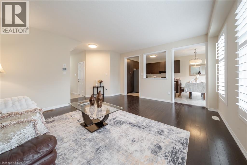 Living area featuring dark wood-finish flooring and ample natural light from windows with plantation shutters