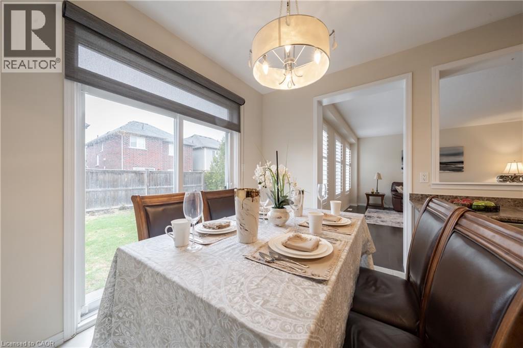 Dining area featuring a contemporary chandelier, sliding glass door with roller shades, and a stone-finish countertop
