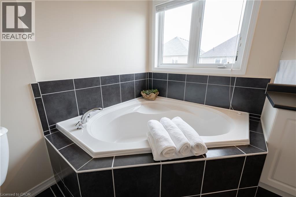 Corner soaking tub with a tiled surround and integrated deck-mounted faucet