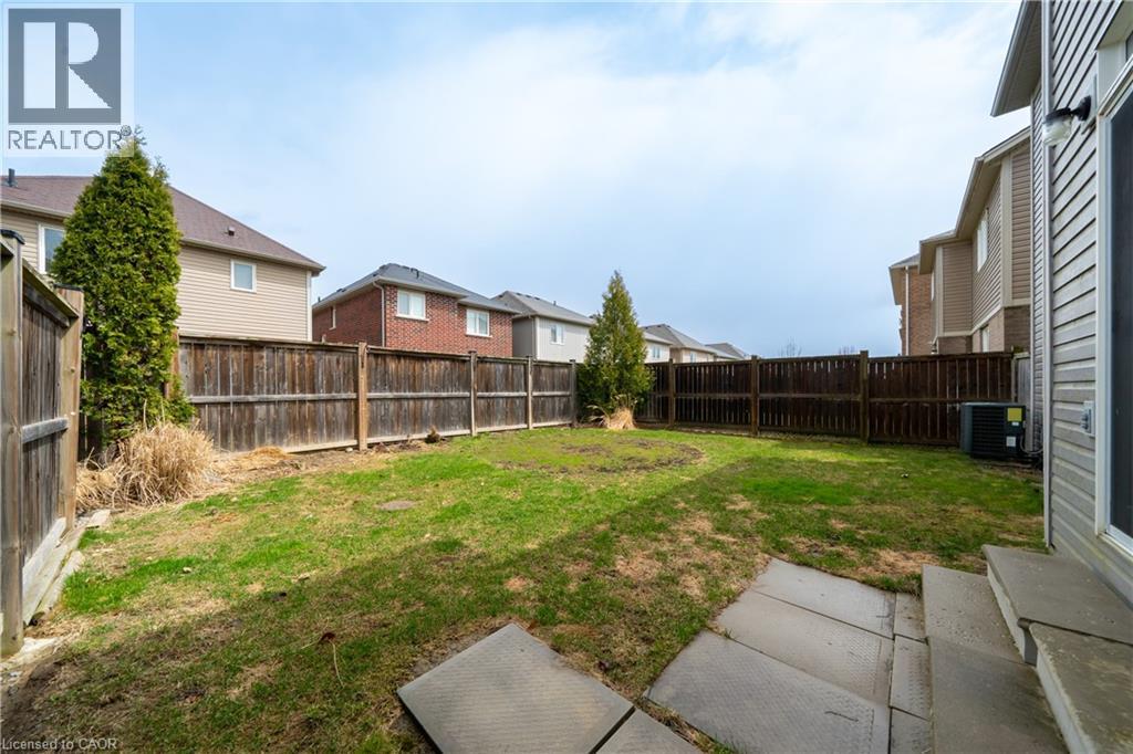 Expansive backyard featuring a manicured lawn and mature privacy trees
