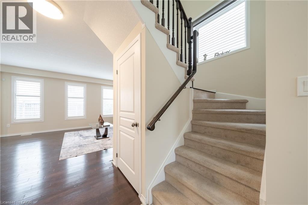 Carpeted staircase with black spindle railing and dark wood-finish handrail