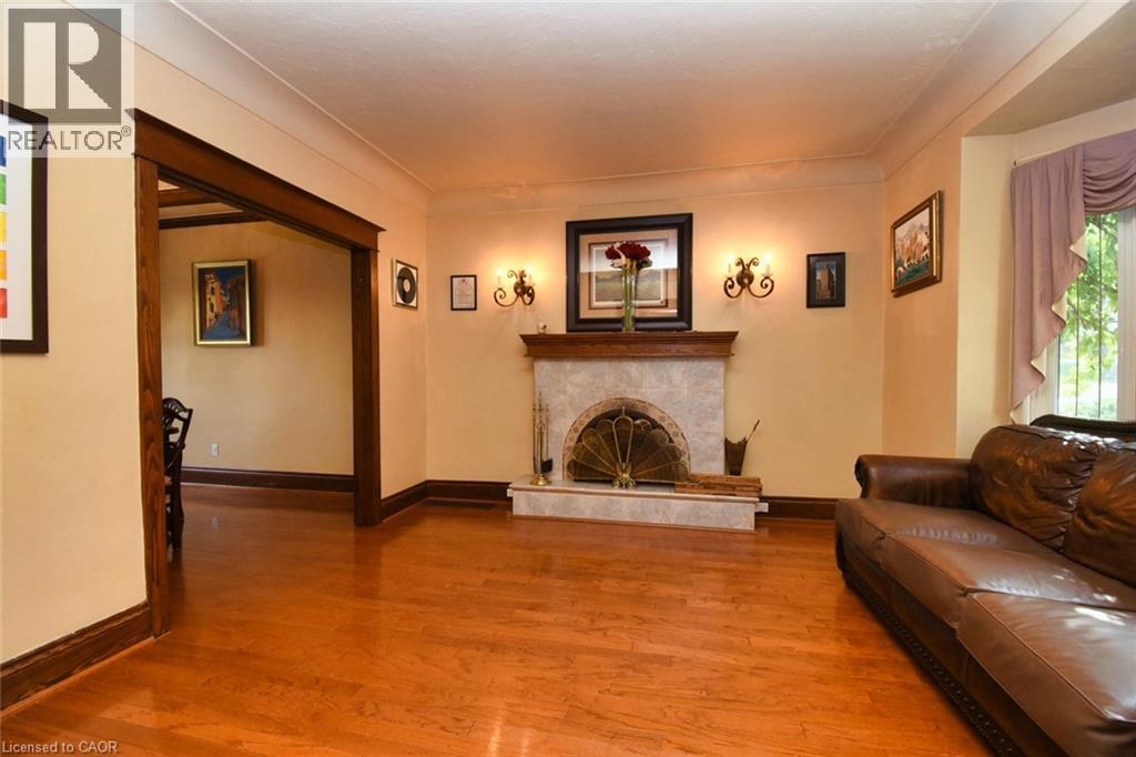 Living area featuring wood-finish flooring and a fireplace with a stone surround and a decorative metal screen