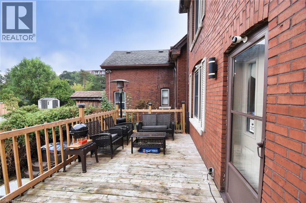 Exterior brick construction with a wood deck featuring a natural wood railing