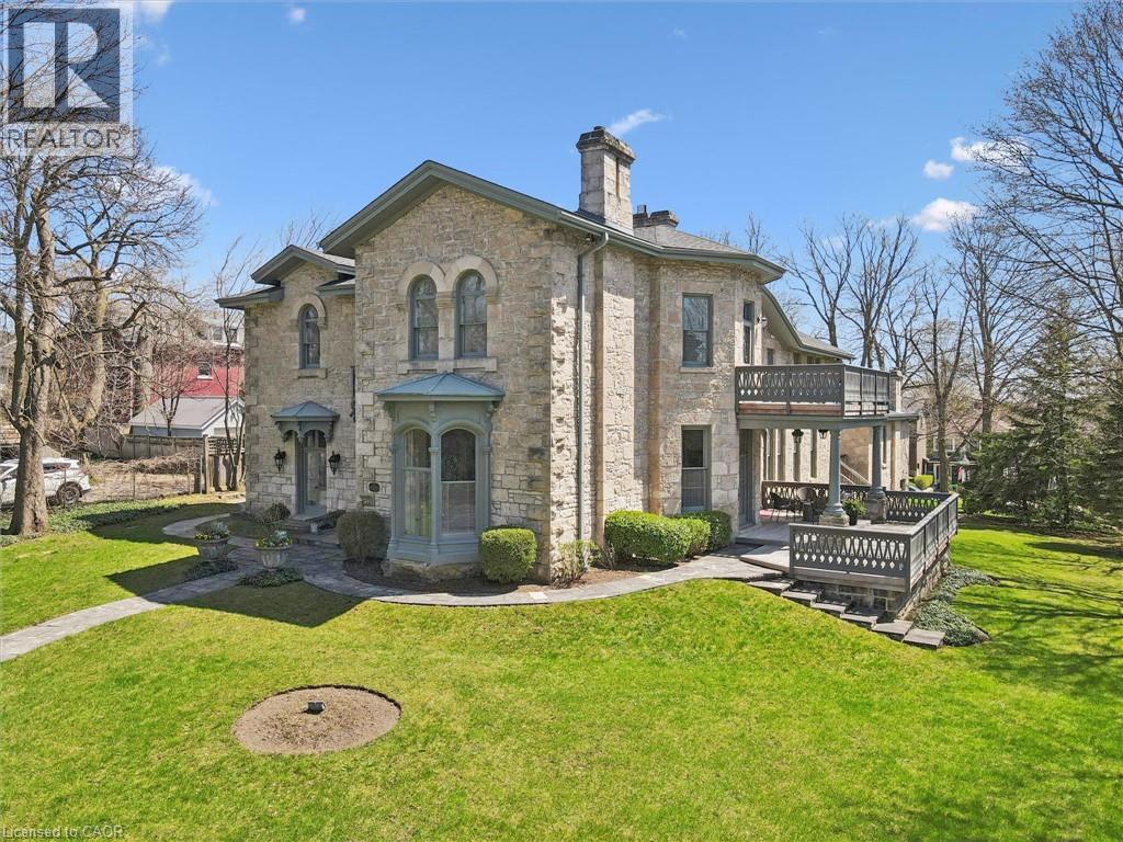 Stone exterior with arched windows, a prominent bay window, and a multi-level deck
