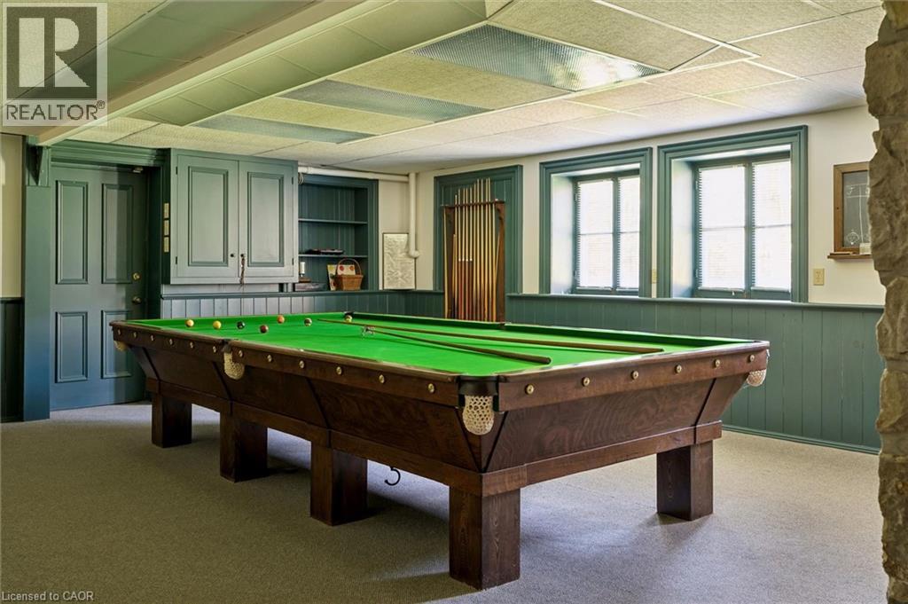 Recreation room featuring a pool table, wall-mounted shelving, built-in cabinetry, and wainscoting