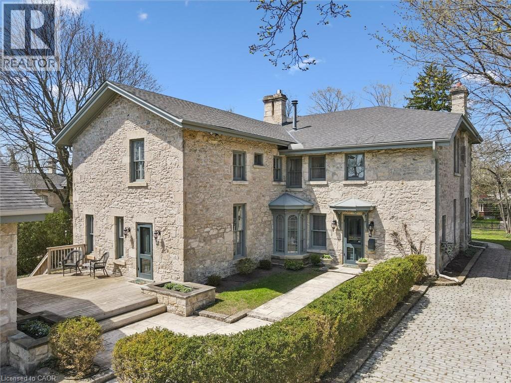 Stone exterior residential property featuring a multi-level composite deck, bay window, and gabled roofline