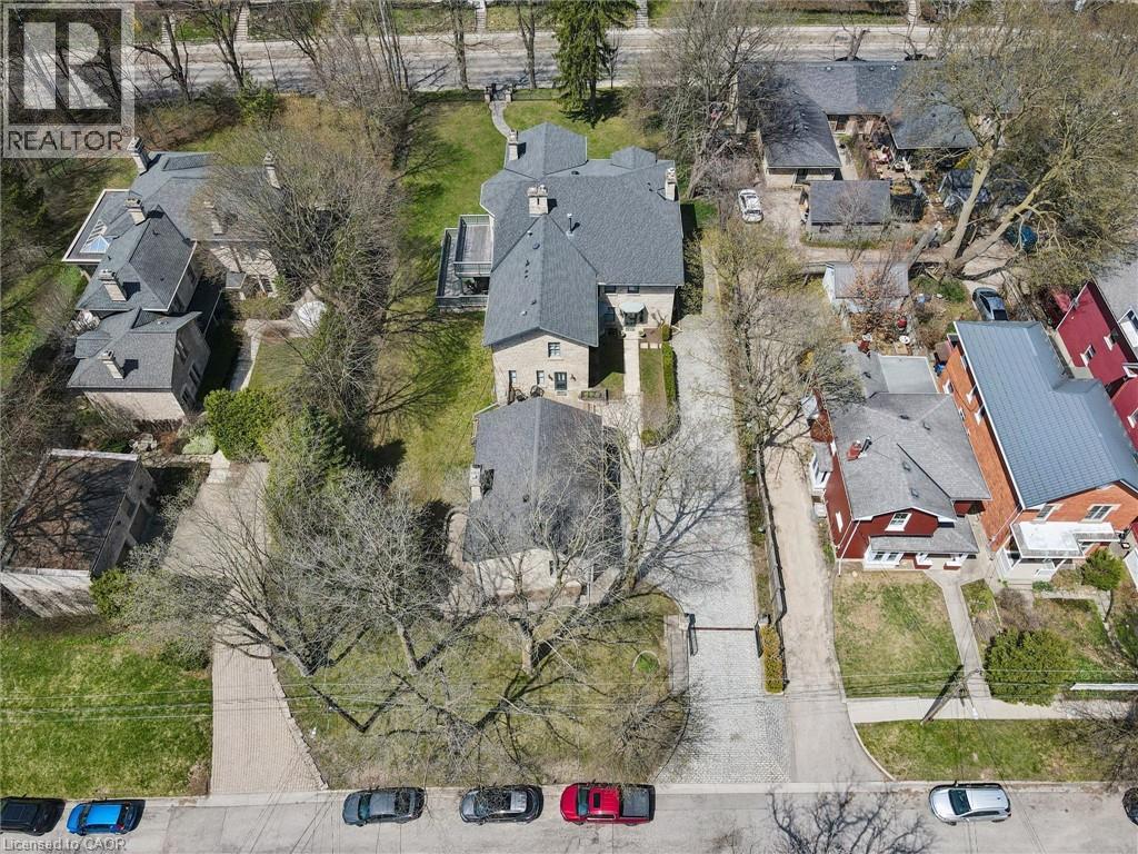 Stone exterior residence with a multi-gabled roofline, multiple chimneys, and a prominent skylight
