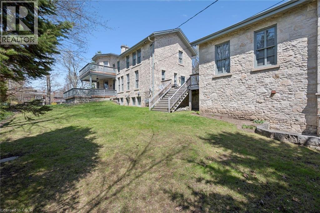 Stone exterior architecture featuring multiple levels and an elevated deck with balustrade