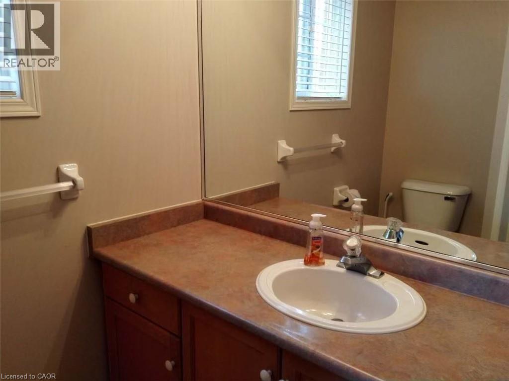 Bathroom vanity featuring a wood-finish base cabinet, a laminate countertop, and an integrated oval sink with a chrome faucet