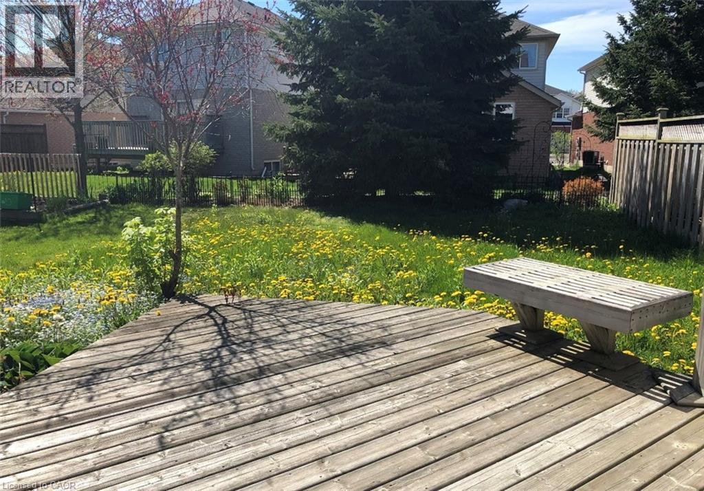 Expansive wood deck with a built-in slatted bench, overlooking a spacious lawn