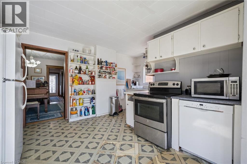 Kitchen featuring patterned flooring, white cabinetry, and a built-in stainless steel range