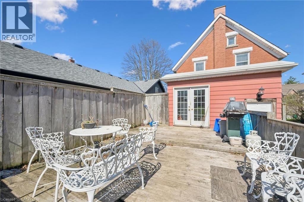 Expansive outdoor deck area featuring a wood fence perimeter and double French doors providing direct access to the interior