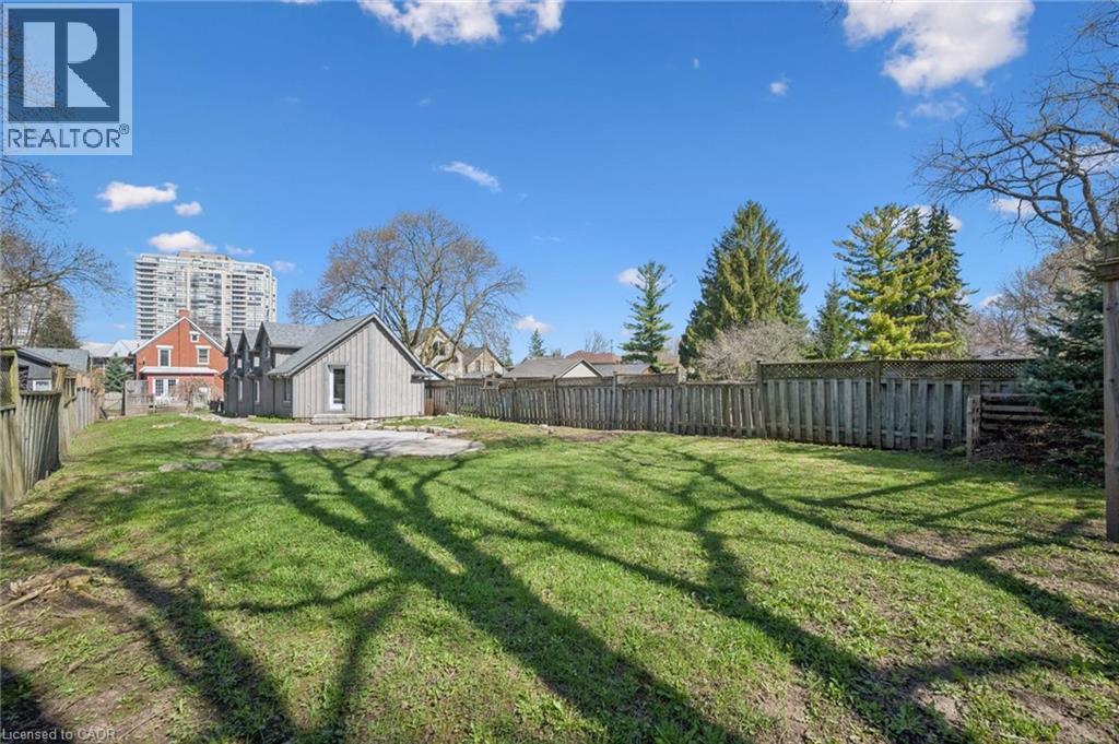 Expansive grassy yard with wood fencing and mature trees