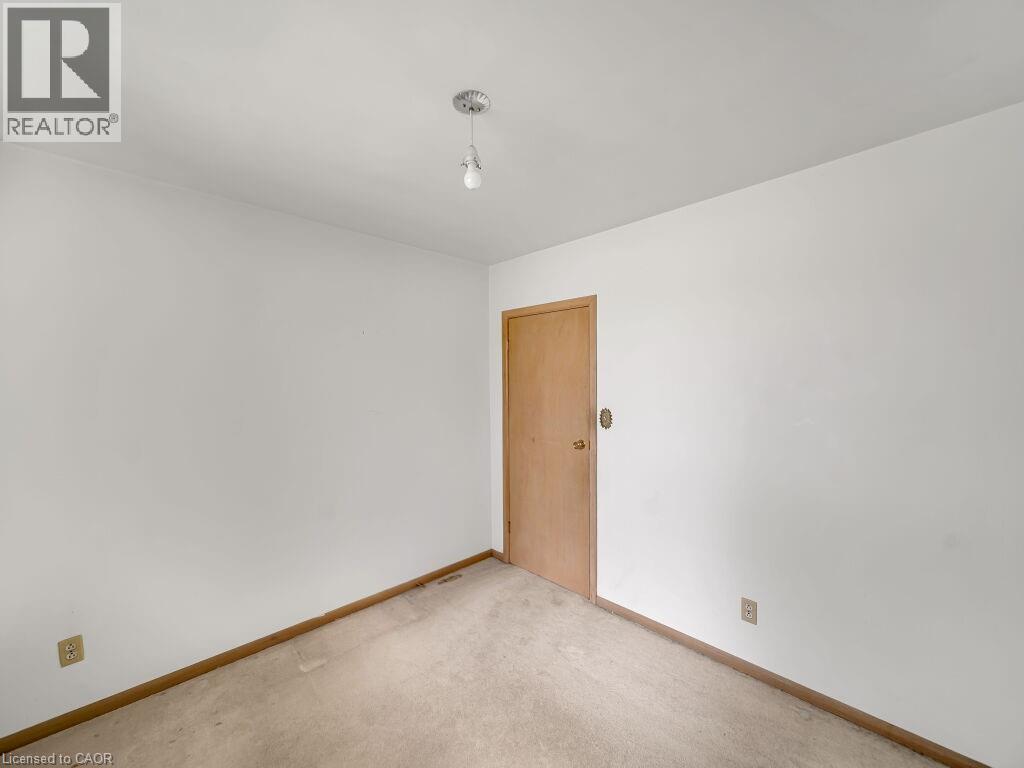 Interior room featuring light-toned walls, a neutral carpeted floor, and a flush-mount ceiling light fixture