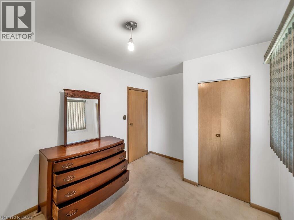 Neutral wall paint with carpet flooring, a flush-mount light fixture, and a wood-finish bi-fold closet door