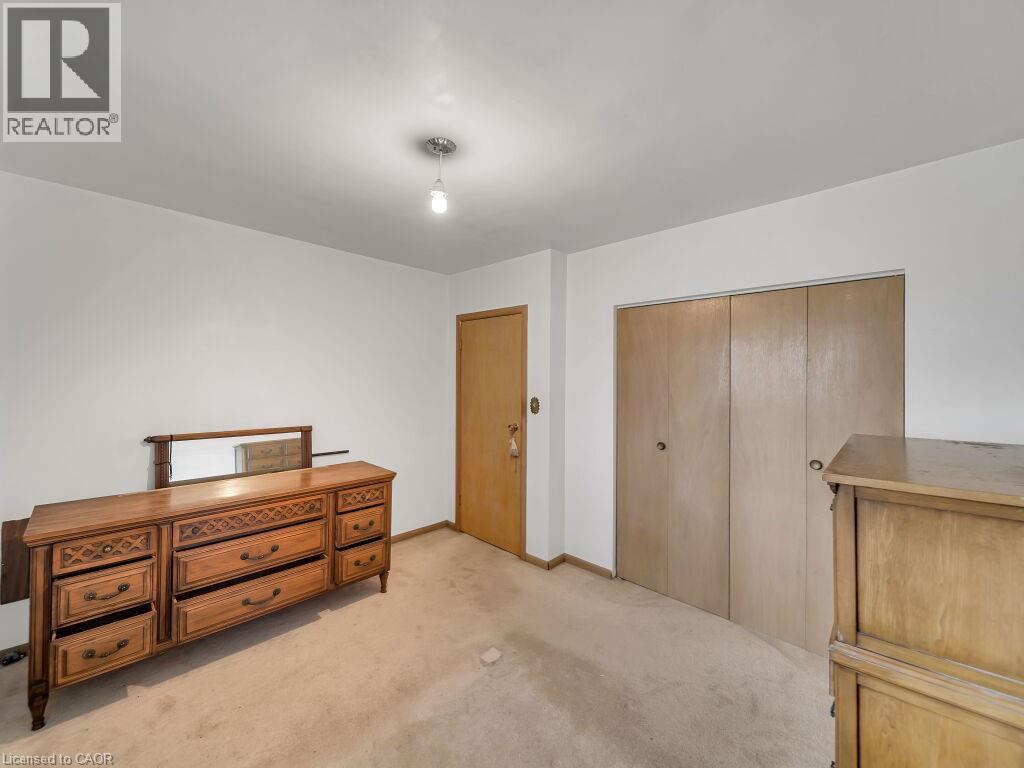 Neutral wall finishes with a ceiling-mounted light fixture, wood-finish interior door, and dual wood-finish closet doors