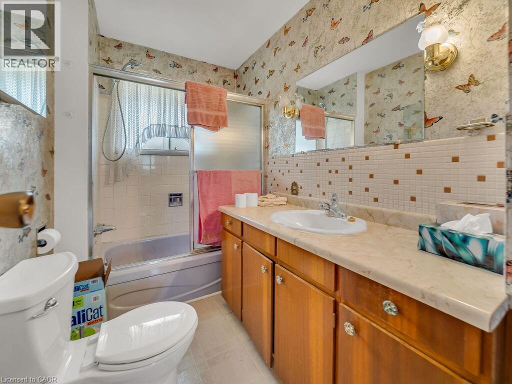 Bathroom featuring a built-in vanity with a cream-toned countertop, wood-finish cabinetry, and an integrated sink basin