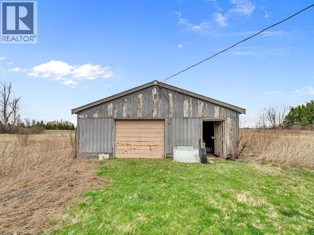 Utility building with a gable roof, roll-up door, and an additional side entrance