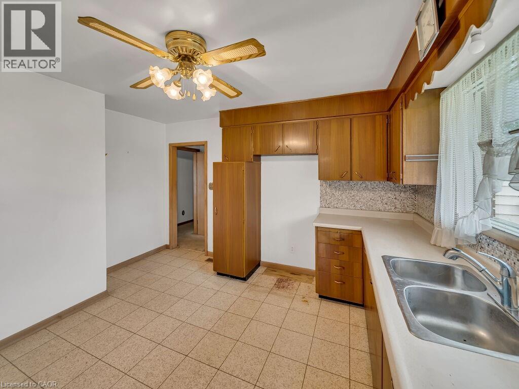 Kitchen featuring wood cabinetry, laminate countertops, and a double basin stainless steel sink