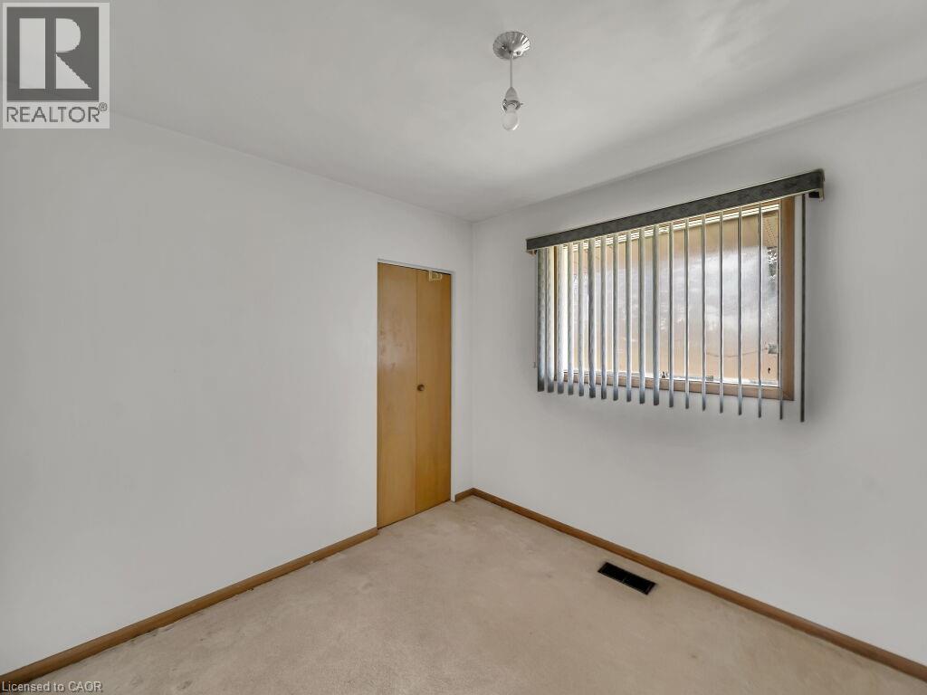 White-painted walls with light-toned carpeting and wood-finish baseboards