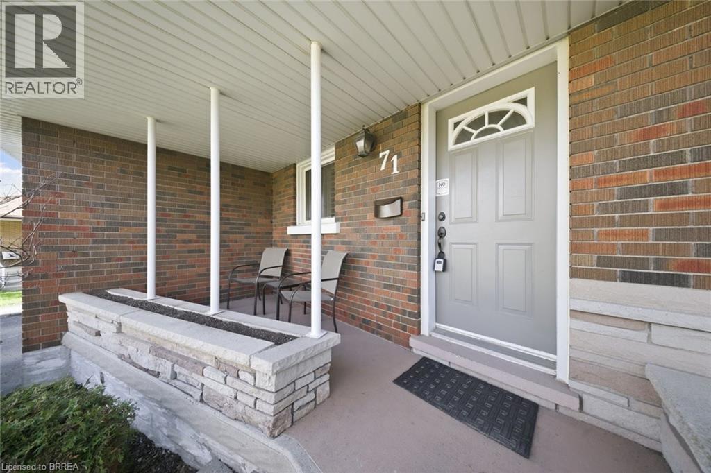 Covered front porch featuring a brick exterior and a stone planter box