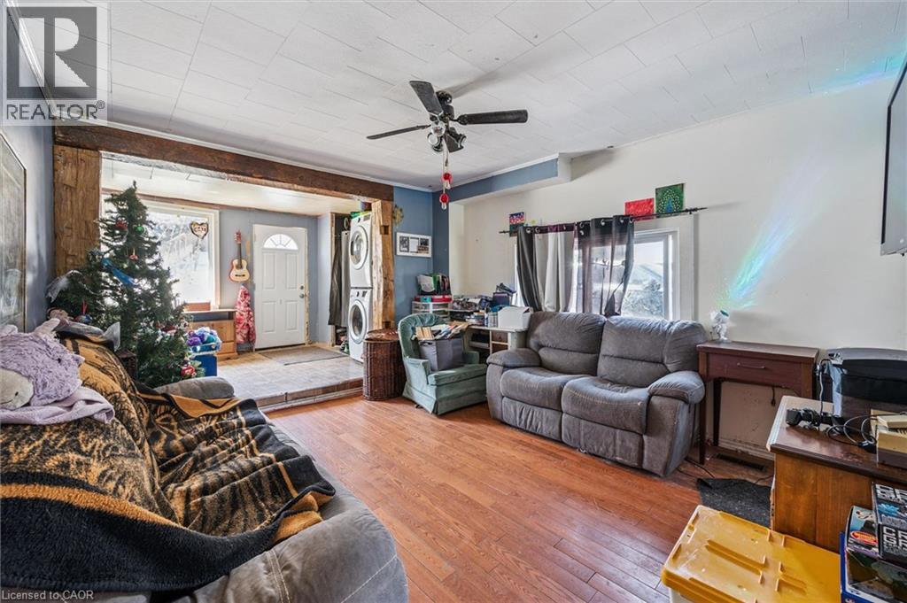 Living area featuring wood-finish flooring and a ceiling fan