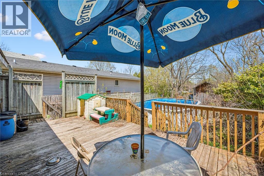 Expansive wooden deck featuring perimeter railing, a privacy fence with lattice accents, and an above-ground pool