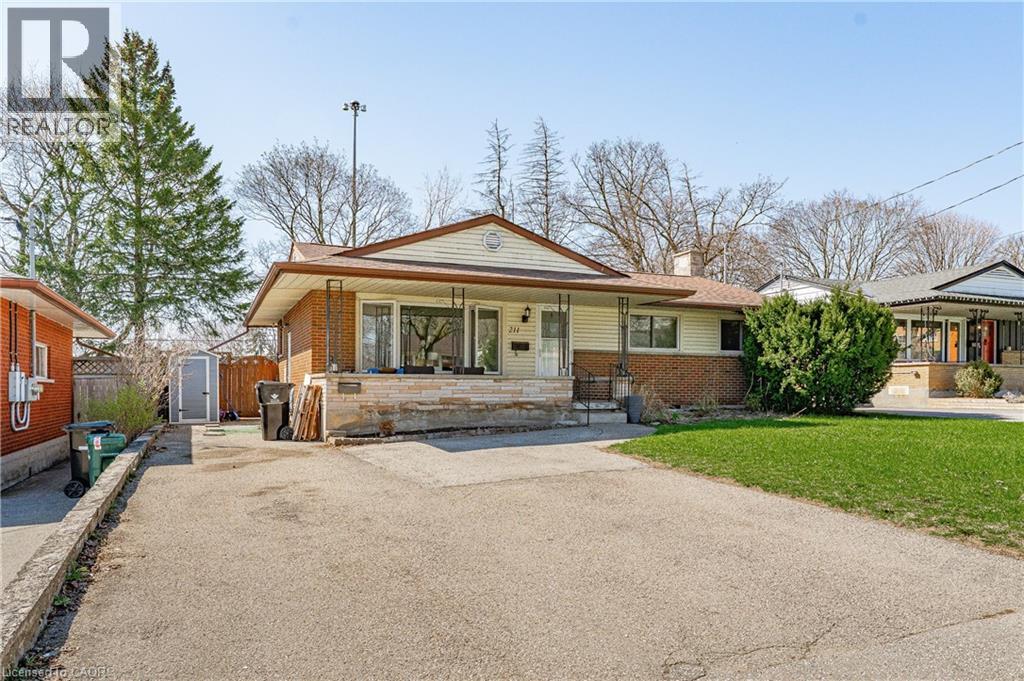 Bungalow exterior featuring brick and siding, a covered front porch, and a paved driveway