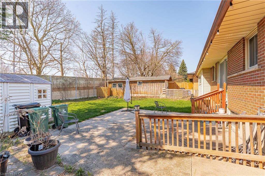 Concrete patio with a wood-finish deck and railing, overlooking a lawn
