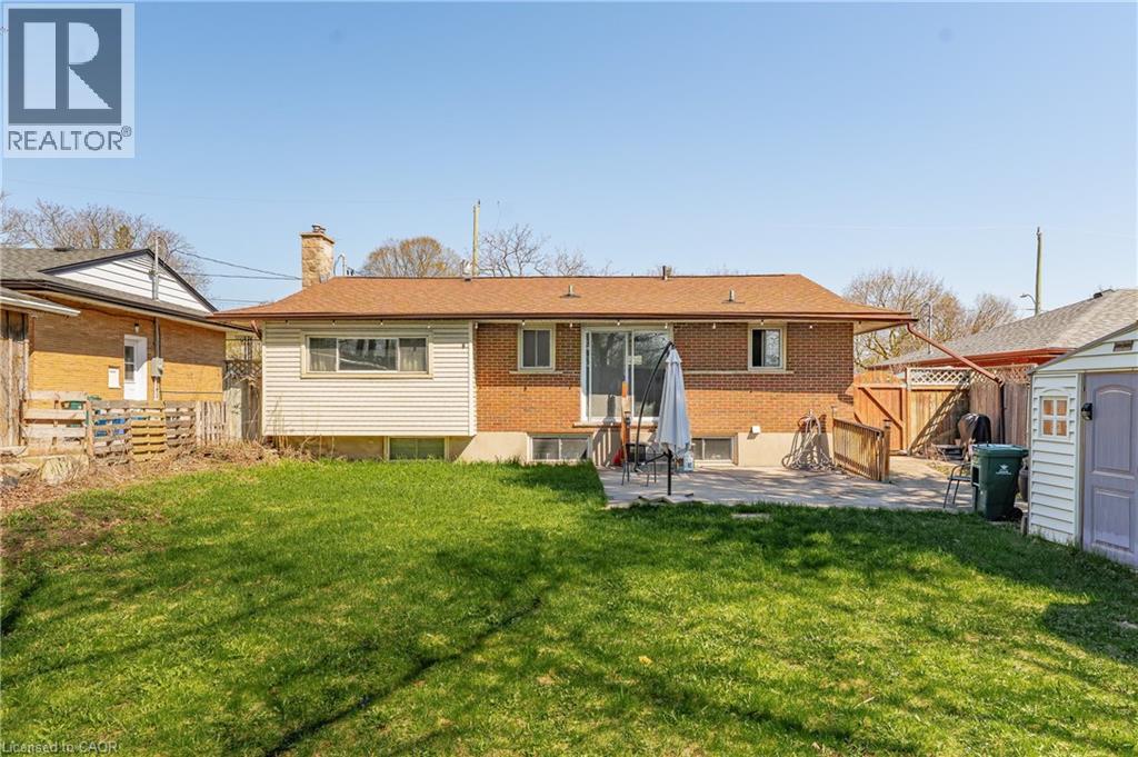 Expansive green lawn with a rear patio featuring a sliding glass door entry to the home
