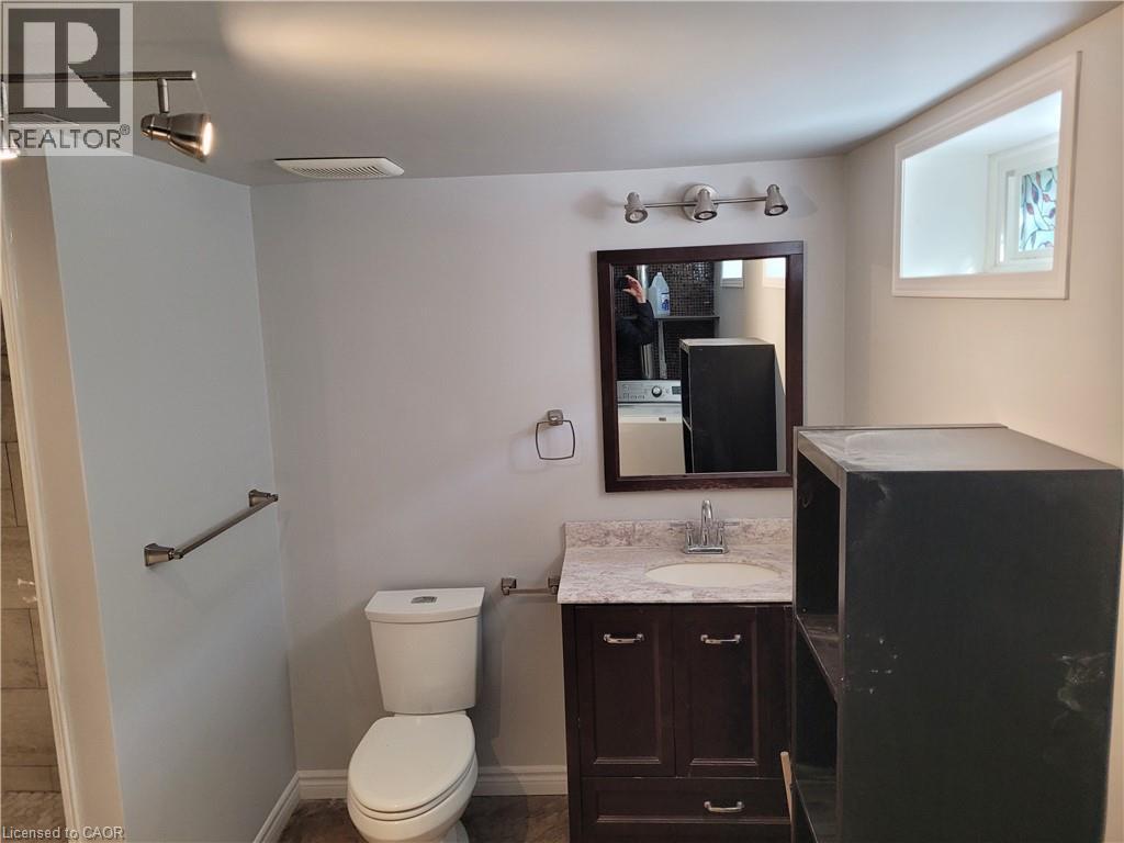 Bathroom featuring a modern vanity with a light-colored countertop and a dark wood-finish cabinet