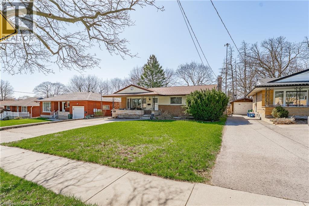 One-story residence featuring a front lawn, paved driveway, and established front yard landscaping