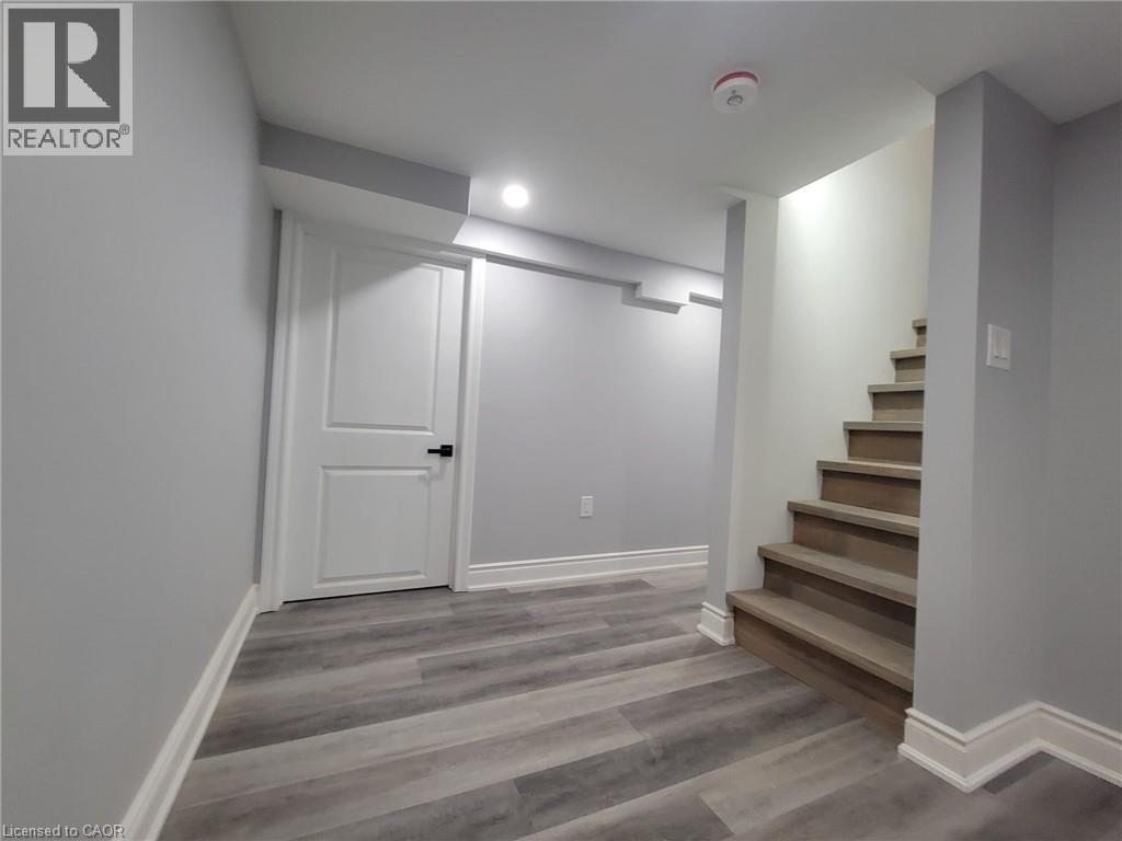 Finished lower level featuring wood-finish flooring, light grey wall paint, and white baseboards