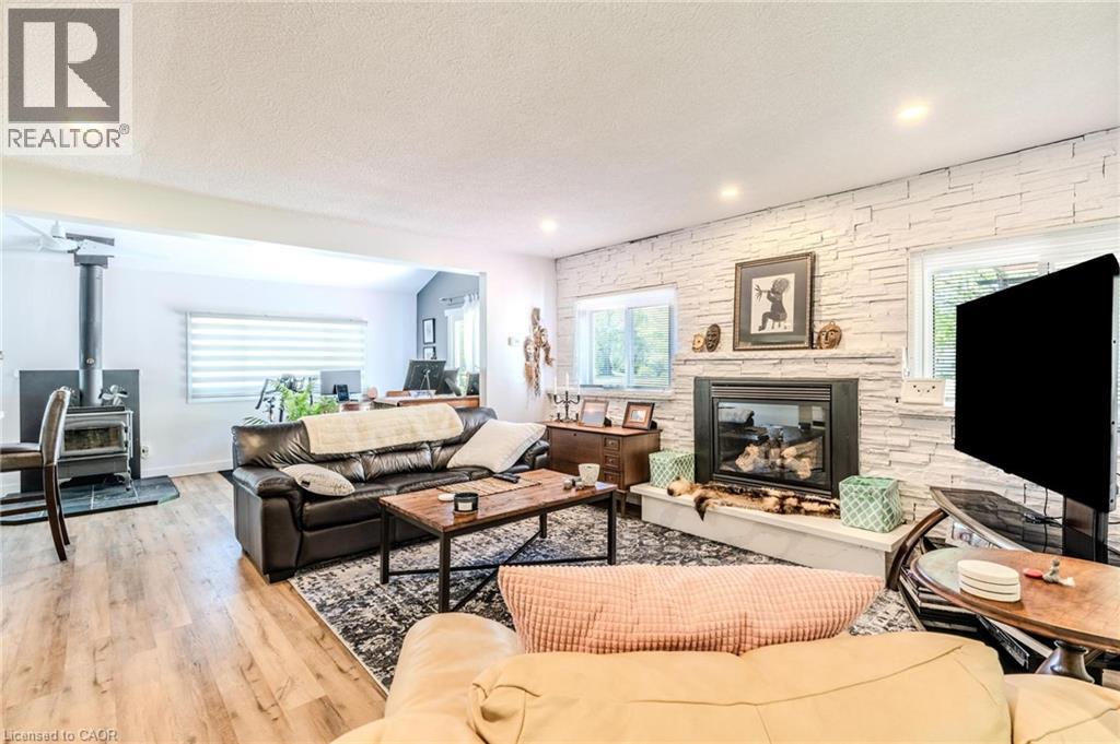 Spacious living area featuring a prominent fireplace with a stacked stone surround and a substantial hearth