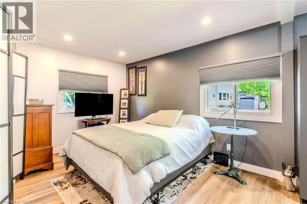 Bedroom featuring recessed lighting, light wood-finish flooring, and two windows with blinds